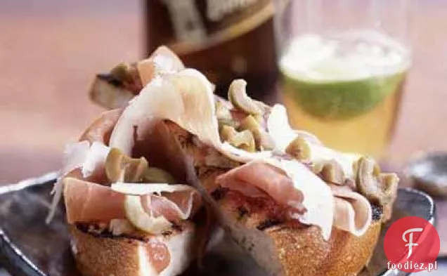 Chleb grillowany z szynką Serrano, Manchego i oliwkami