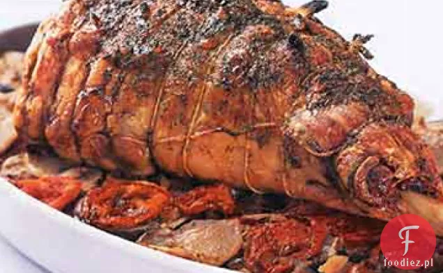 Noga pieczonej jagnięciny na ziemniakach, bakłażanach i pomidorach